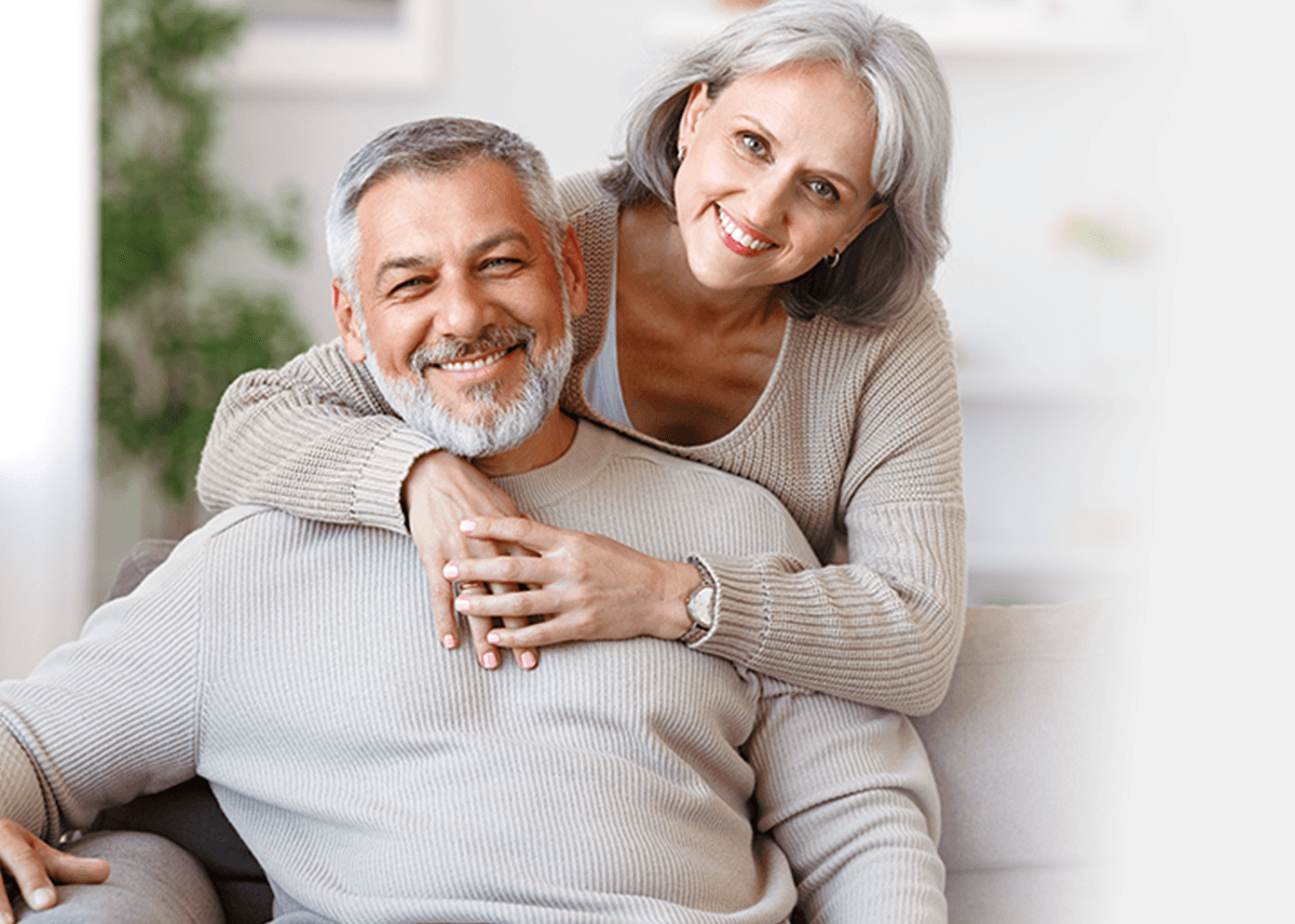 Couple enjoying their restored smiles at home